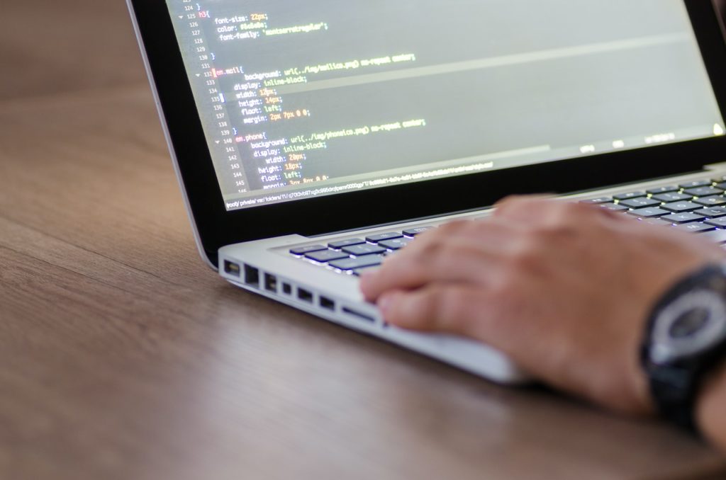 Mann tippt auf einem Laptop